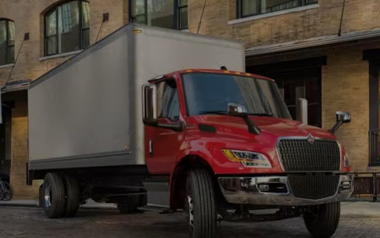 A red box-style delivery truck, the kind of larger delivery rig this job drives