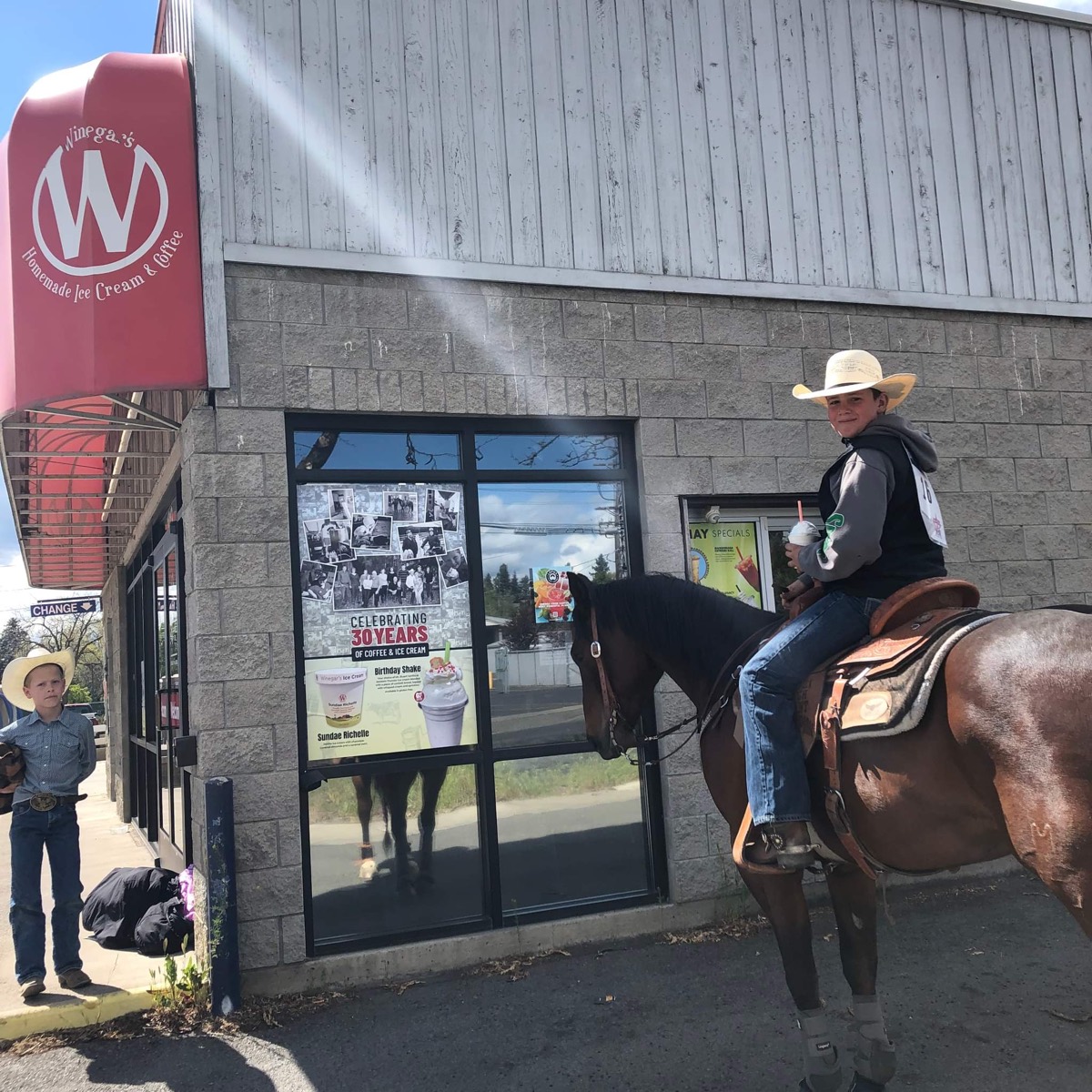 Young cowboys — one on horseback — at the Winegar's University & Alder window
